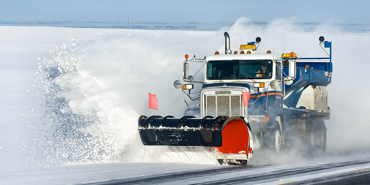 Snow plow clearing highway
